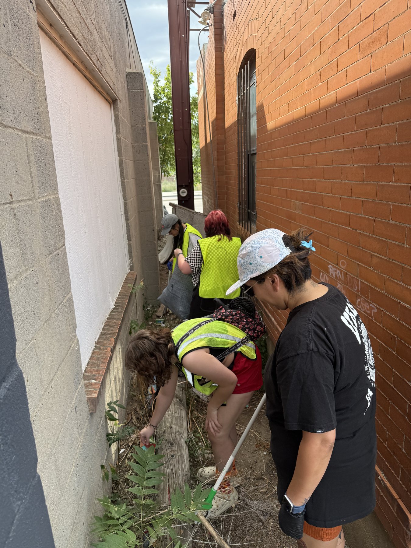 Sophia Cochran and community members cleaning an alley during a neighborhood cleanup activity