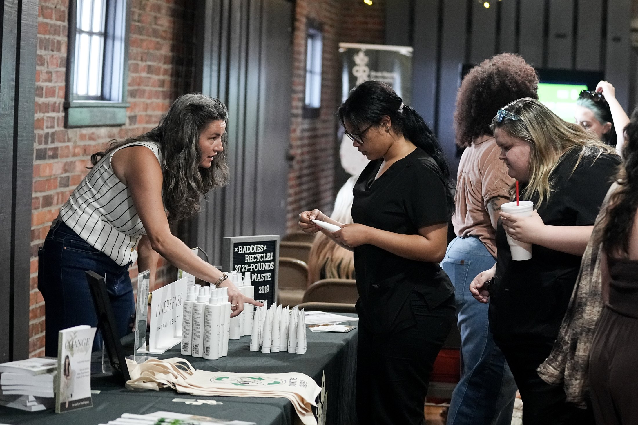 Participants engaging with sustainability resources at the Myrtle Beach Green Salon Impact Tour stop